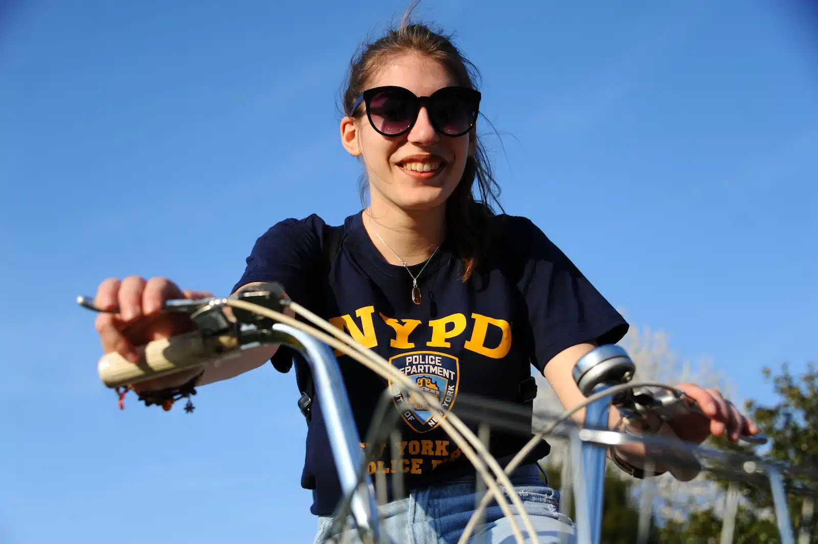 woman in black and yellow crew neck t-shirt riding bicycle during daytime